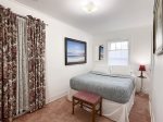 The bedroom is just off of the living room and features a queen bed